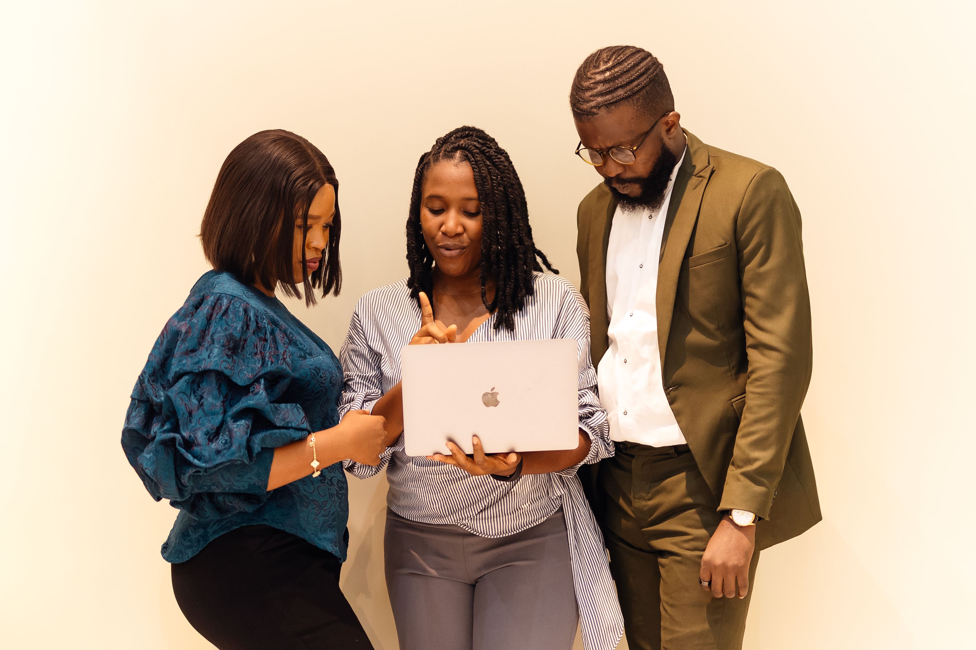 Nigerian business professionals collaborating around a laptop in a Lagos office